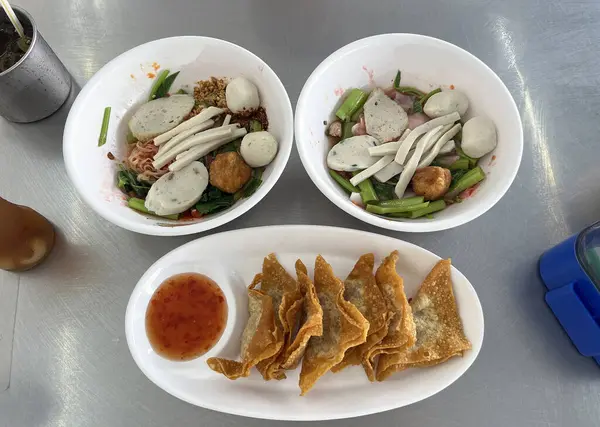 Erişte mayalanmış pembe tofu çorbası ve yanında kızarmış domuz pastırması.