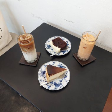 Bira keki, Bask peynirli keki, buzlu kahve ve Kafe Masasında Tayland sütlü çayı.