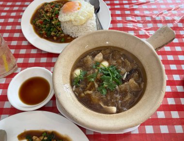 Yağda yumurta ve kil çömlekte balık çorbası ile fesleğenli domuz eti.