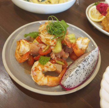 Baharatlı karides salatası ve ejderha meyveli hamachi sashimi.