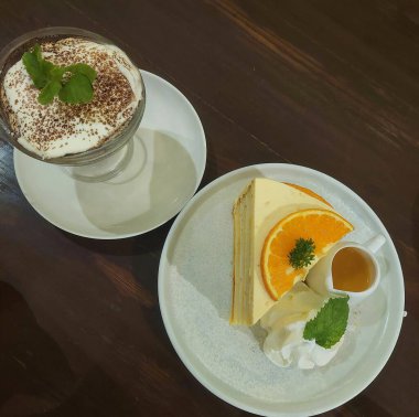 Yemek masasında portakallı pasta ve tiramisu servis ediliyor.
