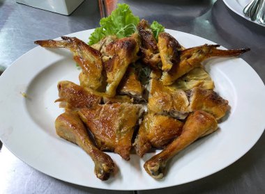 Tayland restoranında servis edilen beyaz tabakta ızgara tavuk.