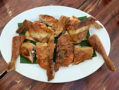 Tayland restoranında servis edilen beyaz tabakta ızgara tavuk.