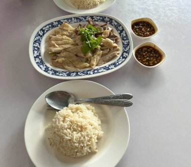 Pirinç, haşlanmış tavuk, sakatat ve sosla servis edilen tavuk pilavı.