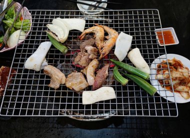 Masa mangalı ve garnitürlü Kore barbekü restoranı atmosferi