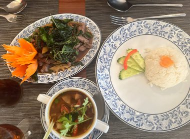 Tayland restoranında kızarmış fesleğen, baharatlı karides çorbası ve pilav.