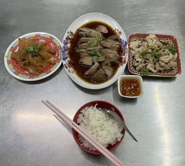 Çin usulü pişmiş kaz, domuz bağırsağı ve pirinç ile servis edilen susam yağı denizanası..