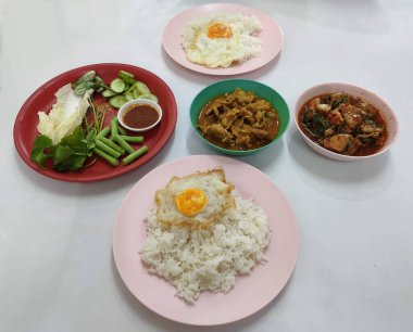 Üzerine kızarmış yumurta, domuz eti, köri ve kırmızı köri sosu.