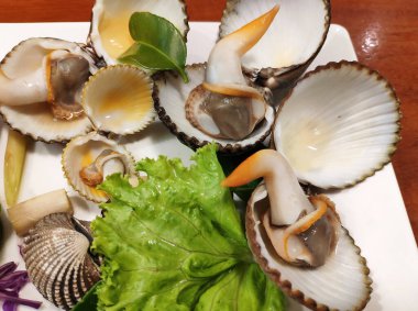 Taze yerel midyeler parlak turuncu kanatlarını sergiliyorlar. Tayland, Phuket 'ten eşsiz ve geleneksel bir deniz ürünleri lezzeti..