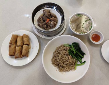 Çin usulü kuru erişte, börek, domuz pirzolası ve çorba.