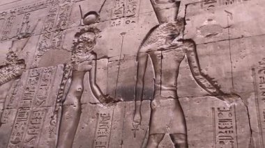 Edfu, Mısır 16 Aralık 2018: Eski Mısır 'ın en iyi korunmuş tapınaklarından biri olan Edfu Tapınağı' nın dış duvarlarındaki yardım oymaları, şahin tanrı Horus 'a adanmıştır..