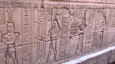 Edfu, Mısır 16 Aralık 2018: Eski Mısır 'ın en iyi korunmuş tapınaklarından biri olan Edfu Tapınağı' nın dış duvarlarındaki yardım oymaları, şahin tanrı Horus 'a adanmıştır..
