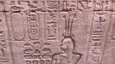 Edfu, Mısır 16 Aralık 2018: Eski Mısır 'ın en iyi korunmuş tapınaklarından biri olan Edfu Tapınağı' nın dış duvarlarındaki yardım oymaları, şahin tanrı Horus 'a adanmıştır..