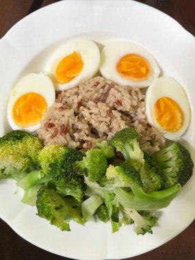 Esmer pirinç, iki haşlanmış yumurta ve buğulanmış brokoli ile basit ve sağlıklı bir yemek..