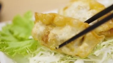 Popüler bir Japon hamur tatlısı olan Gyoza, kıyma ve sebzelerle dolu lezzetli ve tatmin edici bir yemektir. Tavada kıtır kıtır kızartılmış, bu hamur köfteleri genellikle sosla servis edilir..