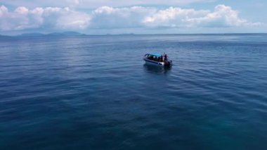 Bu çarpıcı dron çekiminde küçük bir tekne okyanusun berrak sularında huzur içinde yüzüyor. Denizin masmavi mavisi, teknenin parlak beyazıyla çelişiyor. Huzurlu bir his yaratıyor..