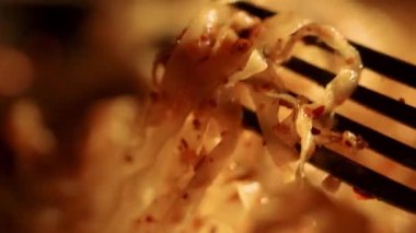 Bu cezbedici yakın plan çekimde canlı renkler ve kurutulmuş Tom Yum eriştesinin baharatlı ve keskin çorbası, mükemmel pişirilmiş eriştesi ve karides gibi çeşitli malzemeleriyle