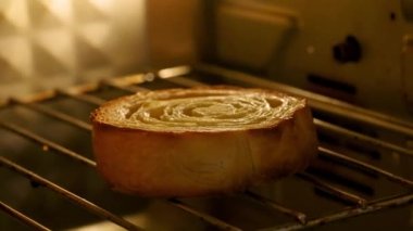 Fırında bir kıvrık pişiyor. Altın-kahverengi hamur işi şişiyor ve sıcaklık arttıkça çıtır çıtır oluyor. Nefis bir kokusu var. Havayı dolduruyor. Nefis bir ikram vaat ediyor..