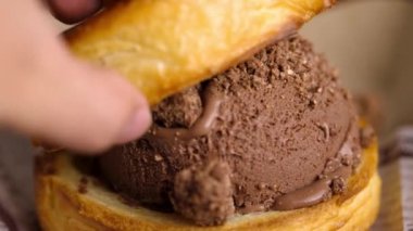Baştan çıkarıcı yakın plan çekimler çıtır kruvasan ve waffle karışımı çikolatalı sandviçler. Zengin çikolatalı dondurma iki katın arasına sıkıştırılır..