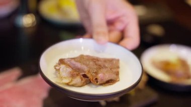 Mükemmel pişirilmiş A5 bifteğine cezbedici bir dokunuş eklenir çünkü şef nazikçe üzerine parlak bir parça jöle sosu koyar. Zengin ve lezzetli tatlar eti tamamlar ve nefis bir tat yaratır. .