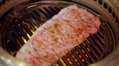 Usta şef, büyüleyici alevlerle çevrili ızgaradaki A5 Wagyu dilimini ustalıkla çeviriyor. Cızırdayan manzara, etin yumuşak, mermer mükemmelliğini, unutulmaz yemek deneyimini gözler önüne seriyor..