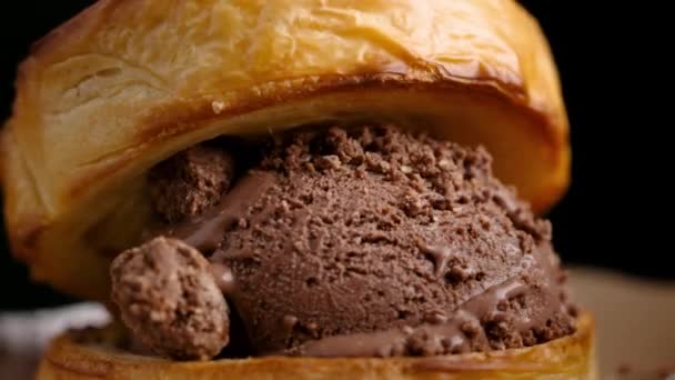 魅惑的なショットは クリスピークロッフルで作られた回転チョコレートアイスクリームサンドイッチをキャプチャします この映画は クリーミーなチョコレートアイスクリームとクリスピーで金色の魅力的な組み合わせを強調しています — ストック動画