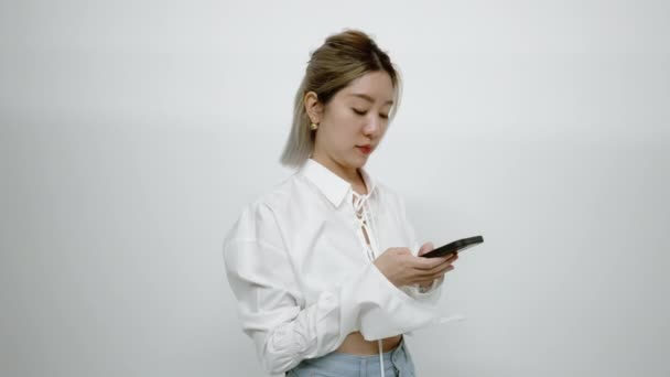 Młoda Azjatka Stoi Pewnie Pochłonięta Rozmową Sms Ową Przez Telefon — Wideo stockowe