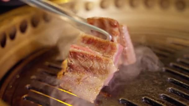 四堆浓密的牛肉在有近景的烤架上发出刺耳的声音 展现了肉质美丽的大理石和质感 烤架上冒出的蒸汽增加了盘子里的水份 — 图库视频影像