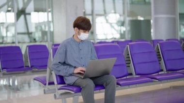 Genç bir girişimcinin koruyucu bir maske takarak havaalanındaki çalışmalarını sürdürmesine hayranlık duyun. Gözlerindeki kararlılıkla, meydan okumaları kucaklıyorlar. Yüksek kalite 4K