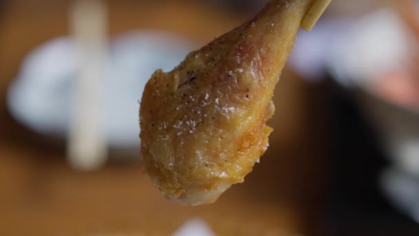 体验烹饪传统的融合 筷子细腻地抓起口吃炸鸡的鸡腿 脆皮和多汁肉质的对比质感使人心旷神怡 — 图库视频影像