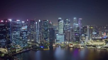 Kendinizi Singapur 'un büyüleyici güzelliğine, gece şehir panoramasına daldırın. Göz kamaştırıcı ışıklar ufku aydınlatıyor, suları yansıtıyor. İkonik simgeler dimdik ayakta duruyor. Yüksek kalite 4k görüntü
