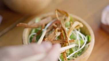 Kültürel mutfak yolculuğu yemek çubukları canlı Japon salatasını zarifçe kavrarken. Taze sebzelerin ve narin lezzetlerin renkli karışımı iç içe geçerek ferahlatıcı bir tat deneyimi yaratıyor..