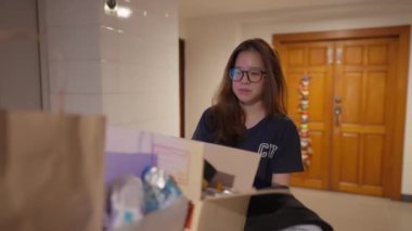 In close-up, a young Asian person pushes a fully packed trolley to the elevator with a visible sense of sadness. their determination , as they navigate lifes challenges with quiet strength.