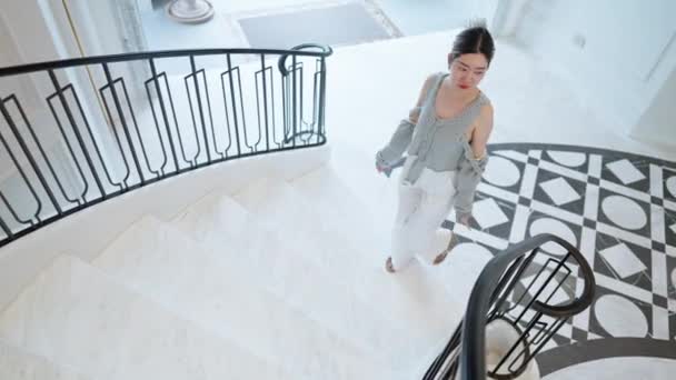 카메라가 위에서 장면을 여성은 호화스러운 계단을 올라갑니다 그녀의 단계는 세련되고 — 비디오