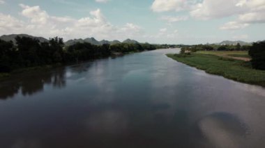 İnsansız hava aracı gibi büyüleyici bir bakış açısı nehrin üzerinde süzülüyor. Kapsamlı manzara, su yolculuğunun dingin güzelliğini yakalar, doğanın ilham verici özelliklerini sunar. Yüksek kalite 4k görüntü