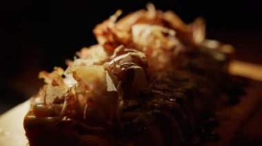 Sahnenin ortasında bir Japon yumurtası var. Chiaroscuro etkisi formunu vurgular, derinlik ve entrika ekleyen gölgeler oluşturur, mutfak zarafetinin sanatsal tasvirini yaratır. Yüksek kalite 4k görüntü