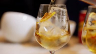 Kurutulmuş portakal dilimleriyle süslenmiş canlı bir portakal kokteyli. Canlı renkler ve ferahlatıcı manzara, buz gibi bir hazzı çağrıştırıyor. Yüksek kalite 4k görüntü