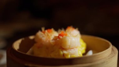 Şımarık sarı Çin Dim Sum 'u, leziz ebi tacı ile taçlandırılmış. Bu mutfak mücevheri, yumuşak ambalajın leziz lezzetleriyle karidesin zenginliğini birleştiriyor. Yüksek kalite 4k görüntü