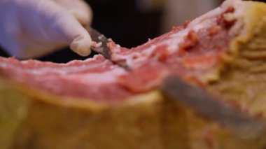Usta şef Iberico jambonu dilimliyor İberya 'nın nefis lezzeti. Sürecin hassasiyeti ve sanatsallığı gurme uzmanlığının özünü yakalıyor. Yüksek kalite 4k görüntü