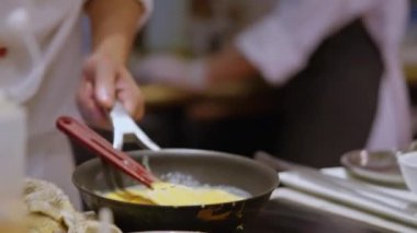 Şef omleti yaratırken uzman bir aşçı ustaca cızırdayan bir tavada omlet çevirir. Yumurtalar kabarık bir başyapıta dönüşür, yetenekli bir şefin özünü yakalar. Yüksek kalite 4k görüntü