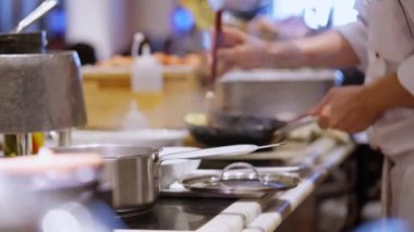 Şef iş başında, yandan bakıyor becerikli bir aşçı yamağı ustası yoğun bir mutfakta çalışıyor. Yoğun bir dikkatle, şef ustalıkla nefis bir başyapıt hazırlıyor, hassasiyet ve tutkuyu somutlaştırıyor..