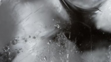 Suya batırılmış buz küpünün yakın çekimi elementlerin birleşimidir. Kristal berrak buz kübü, kısmen su altında, sıvı çevreye karşı büyüleyici bir kontrastlık yaratır. Yüksek kalite 4k görüntü