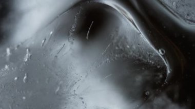 Suda küçük bir baloncukla buz küpüne yakın çekim. Karmaşık bir element oyunu. Kristal berrak buz küpü, yanında küçük bir baloncuk ile büyüleyici bir şey yaratır. Yüksek kalite 4k görüntü