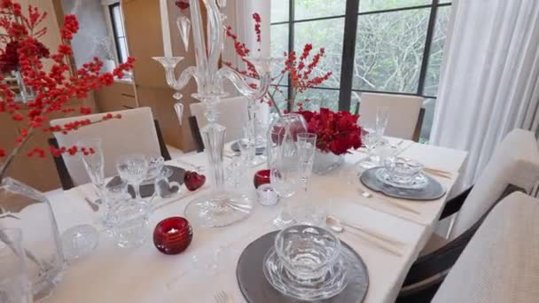お祝いの白と赤の色で飾られたエレガントなクリスマステーマテーブル グリスニングディナーウェア スタイリッシュなナプキン 活気に満ちた休日の楽しいお祝い 季節の魅力を満たした高品質4K — ストック動画