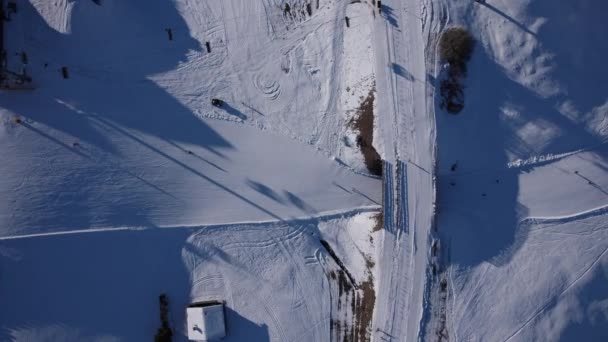 トップビューのドローン飛行は 遠くのスキーで広大な雪に覆われた風景の人々が冬の小さな数字になることをキャプチャします 空中視点 自然の広大な美しさ 高品質の4K映像 — ストック動画