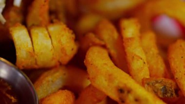 Kıtır kıvırcık patateslerin yakın çekimi, altın-kahverengi dokuları ve kıvrımlı şekilleri vurgulanıyor. Çıtır çıtır ve leziz kızarmış patates aromasını sergilemek için mükemmel. Mutfak temaları için ideal.