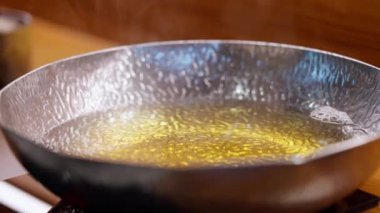 Parlak gümüş bir tencere ve yükselen buharla, zengin, aromatik et suyu ve taze malzemelerin sergilendiği sıcak bir tencerenin yakın çekimi. Sıcak tencerenin sıcaklığını ve toplumsal deneyimini vurgulamak için mükemmel..