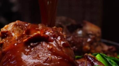 Asyalı domuz bacağının üzerine et suyu dökülerek kaynaması zengin ve lezzetli lezzeti arttırıyor. Buharı tüten, aromatik et suyu taze eti kaplıyor ve geleneksel yemekleri sergiliyor..