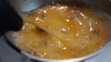 Yumurtaların bir kasede karıştırıldığı yakın plan çekimde yumurta sarısı ve beyazların karıştırılarak zengin, altın bir karışım oluşturulduğu görülüyor. Doğal hareket ve doku, yemek pişirme videoları için mükemmel ev yemeklerini vurgular..