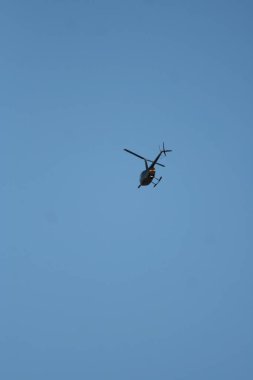 Mavi gökyüzünde uçan bir helikopter